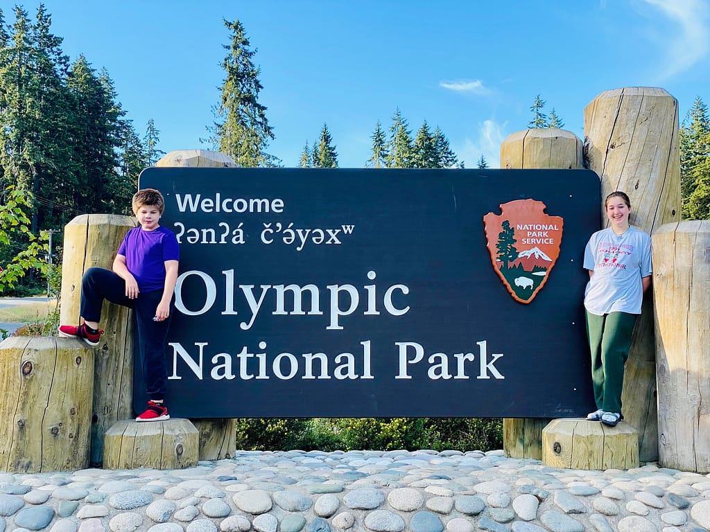 Kids pose at Olympic National Park entrance sign