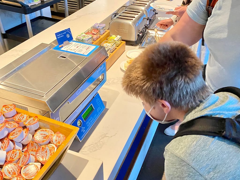 My son watching the pancake machine in the Alaska Airline Lounge at SeaTac Airport