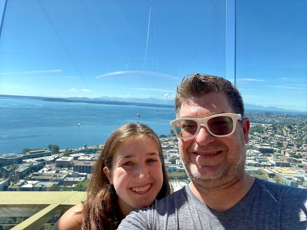 Me and my girl selfie looking towards Olympic mountains from the Space Needle
