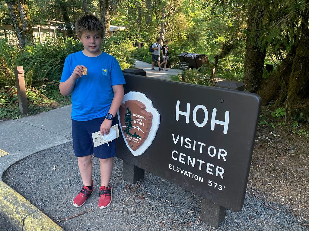 My son holding up his National Parks Junior Ranger Badge in Olympic National Park