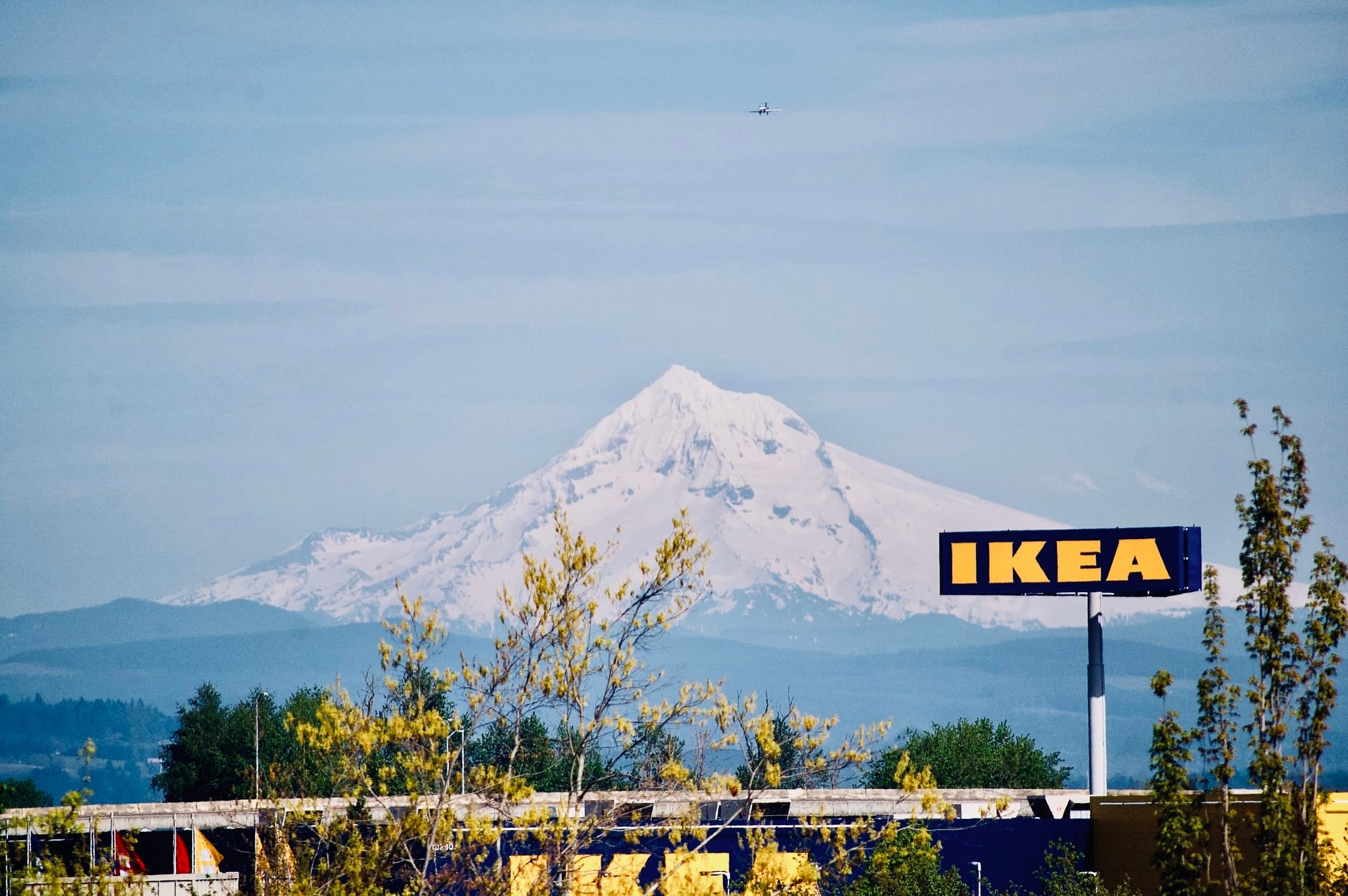 Mt. Hood as seen from Aloft hotel by PDX airport with Ikea sign and airplane on approach to land